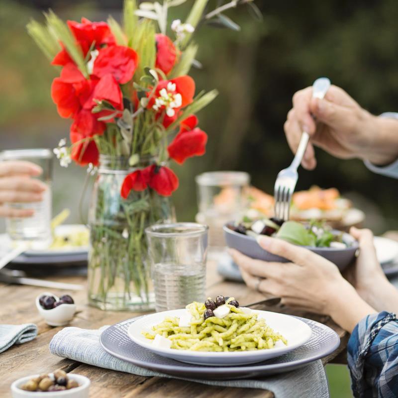 A close-up of a plate with someone serving food